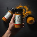 Overhead shot with hand holding Butter Chicken shaker and scattered spice